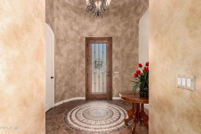 foyer with arched walkways, a chandelier, and baseboards