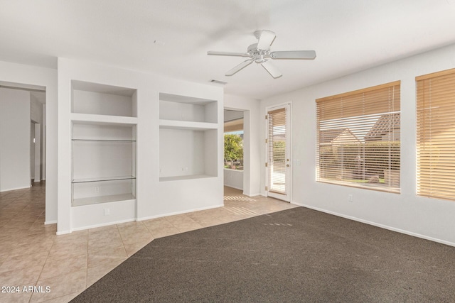 interior space with built in features, ceiling fan, and light tile patterned flooring