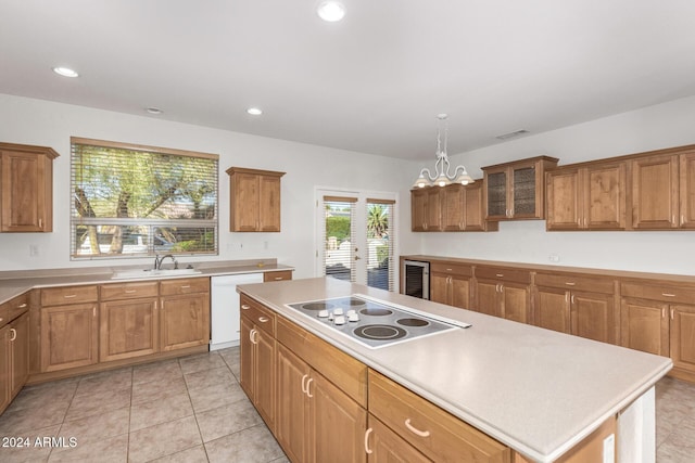 kitchen featuring sink, electric cooktop, decorative light fixtures, dishwasher, and a kitchen island