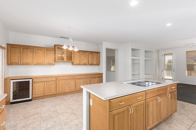 kitchen featuring light tile patterned flooring, a kitchen island, pendant lighting, wine cooler, and cooktop