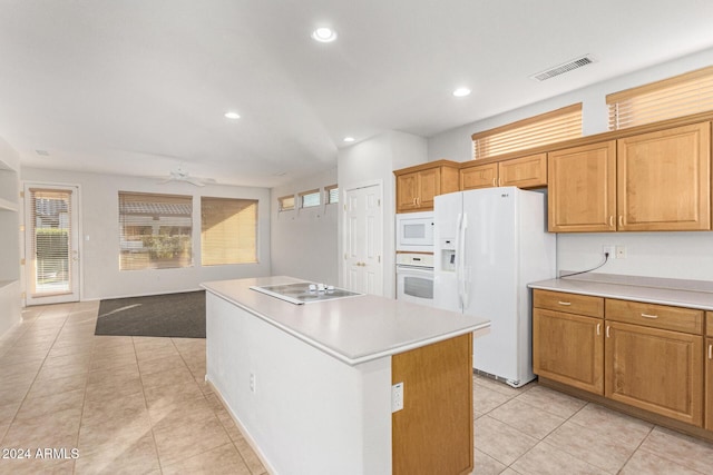 kitchen with white appliances, a center island, ceiling fan, and light tile patterned flooring