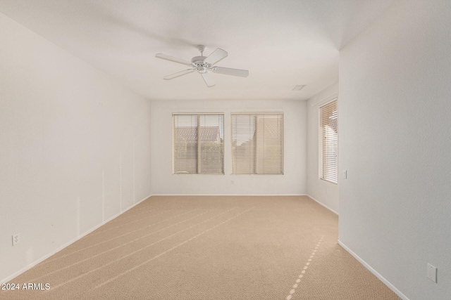 empty room with ceiling fan and light colored carpet