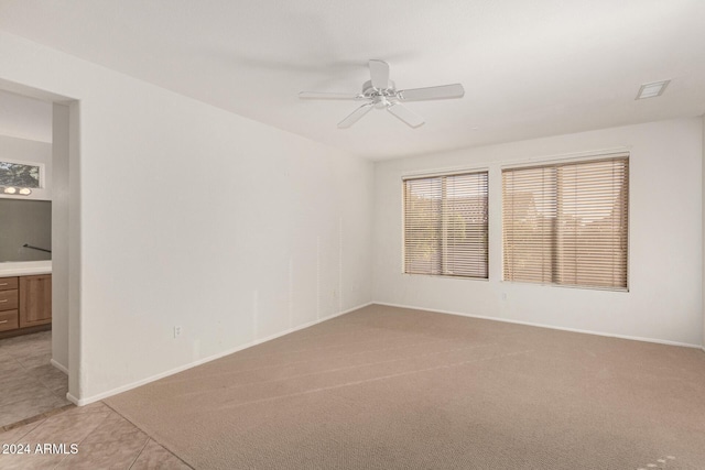 carpeted spare room featuring ceiling fan