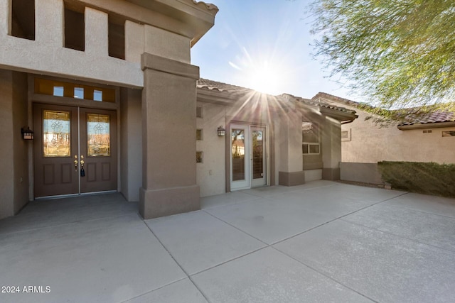 view of exterior entry with a patio area