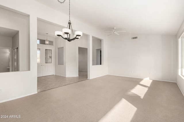 carpeted empty room featuring ceiling fan with notable chandelier