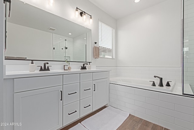 bathroom with independent shower and bath, vanity, and wood-type flooring