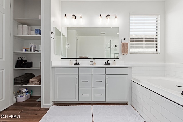 bathroom featuring vanity, wood-type flooring, and shower with separate bathtub