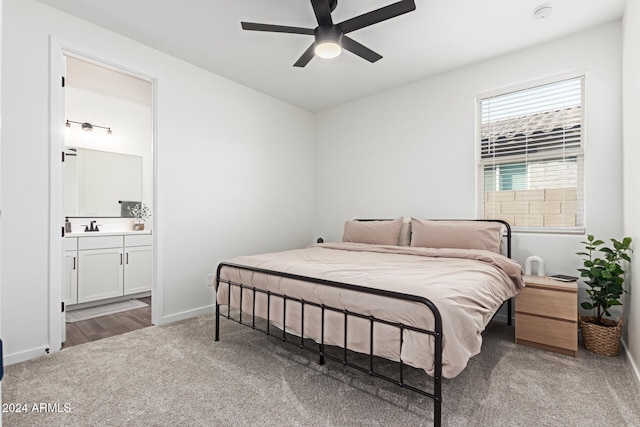 bedroom featuring carpet, ensuite bath, ceiling fan, and sink