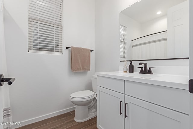 bathroom with vanity, hardwood / wood-style flooring, and toilet