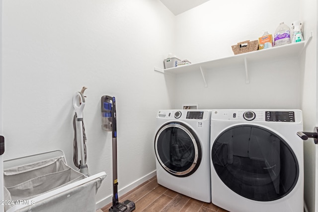 laundry room with washing machine and clothes dryer and light hardwood / wood-style flooring