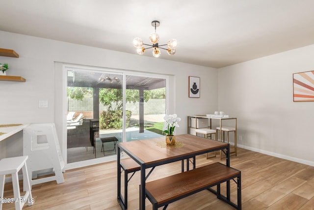dining area with light wood-type flooring, a chandelier, and baseboards