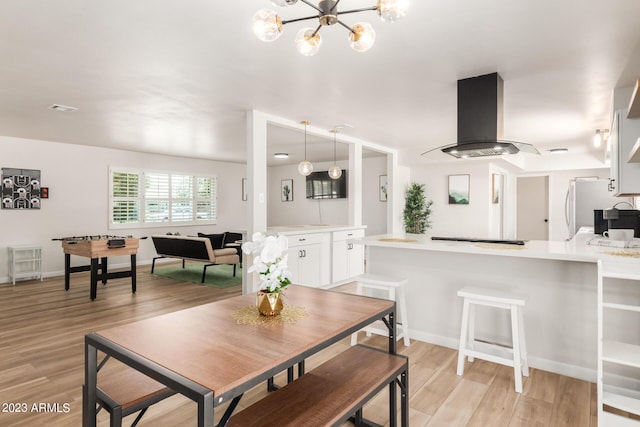 dining room with light wood-style floors, a chandelier, and baseboards