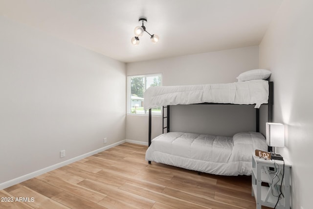 bedroom with light wood finished floors and baseboards