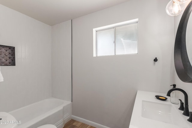 bathroom with a sink, wood finished floors, and bathing tub / shower combination
