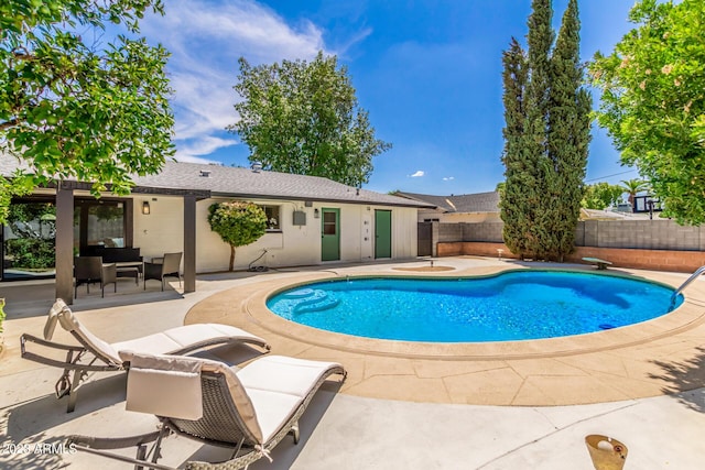 view of pool with a patio and fence