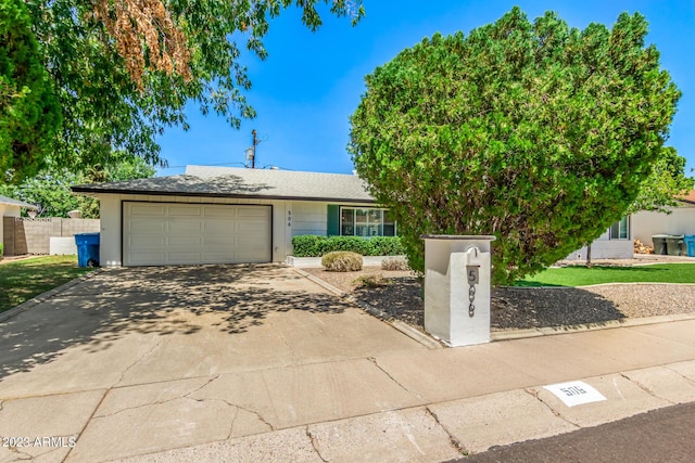 view of front of property with a garage, fence, concrete driveway, and stucco siding