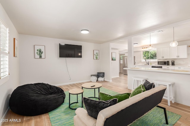 living area with light wood-style flooring and baseboards