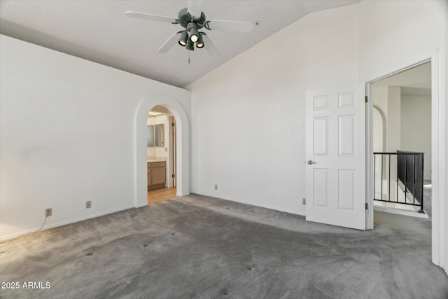 carpeted spare room with vaulted ceiling and ceiling fan