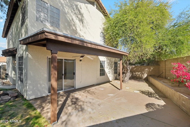 rear view of property featuring ceiling fan and a patio