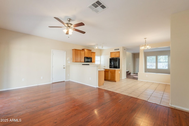 4010 W Fremont Rd, Phoenix, AZ 85041 - unfurnished living room featuring a chandelier, ceiling fan, light wood-type flooring, and baseboards