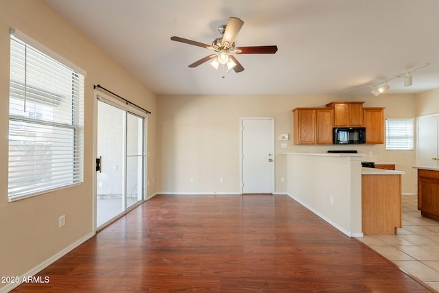 4010 W Fremont Rd, Phoenix, AZ 85041 - kitchen with black microwave, ceiling fan, track lighting, a peninsula, and brown cabinetry