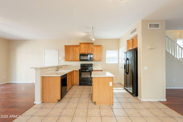 4010 W Fremont Rd, Phoenix, AZ 85041 - kitchen featuring black appliances, a peninsula, a sink, light countertops, and a kitchen island