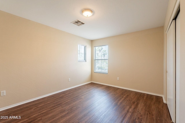 4010 W Fremont Rd, Phoenix, AZ 85041 - unfurnished bedroom featuring dark wood-type flooring, baseboards, and a closet