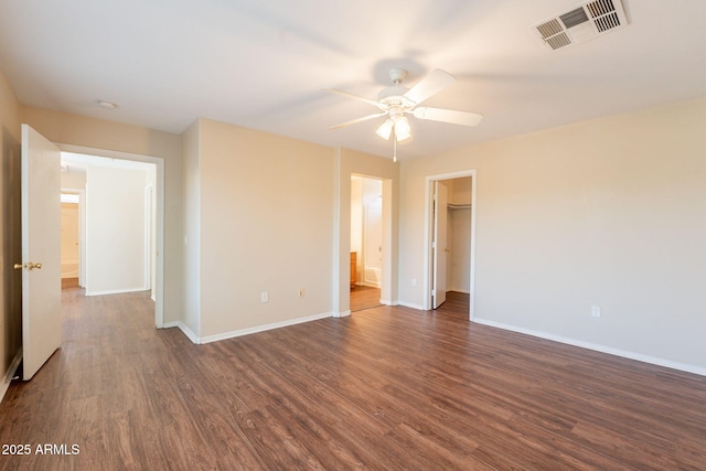 4010 W Fremont Rd, Phoenix, AZ 85041 - unfurnished bedroom with dark wood-style floors, baseboards, a walk in closet, and ceiling fan