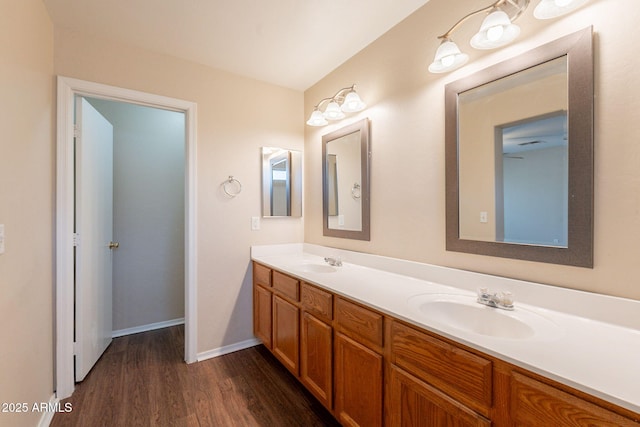 4010 W Fremont Rd, Phoenix, AZ 85041 - bathroom featuring double vanity, wood finished floors, and baseboards
