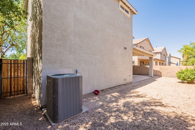 4010 W Fremont Rd, Phoenix, AZ 85041 - view of property exterior with cooling unit, stucco siding, a patio, and a gate