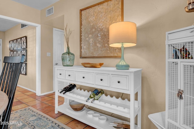 hallway with visible vents, baseboards, and light tile patterned flooring