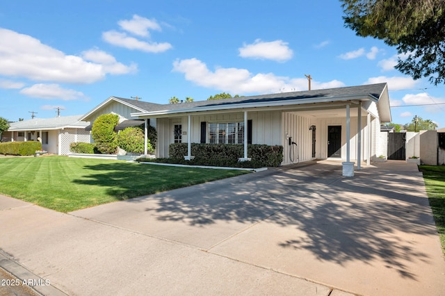 single story home with a front lawn, a gate, board and batten siding, concrete driveway, and an attached carport