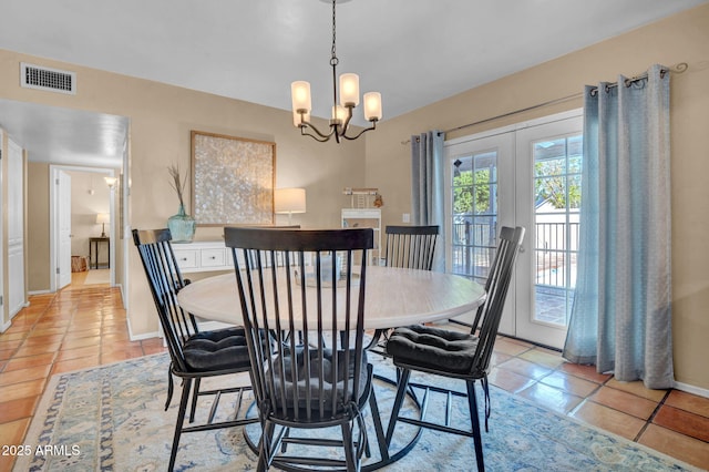 dining room featuring light tile patterned floors, visible vents, a chandelier, and french doors