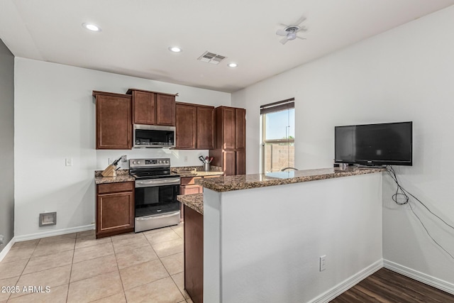 7090 S 252nd Dr, Buckeye, AZ 85326 - kitchen featuring stainless steel appliances, dark stone counters, baseboards, recessed lighting, and dark brown cabinetry