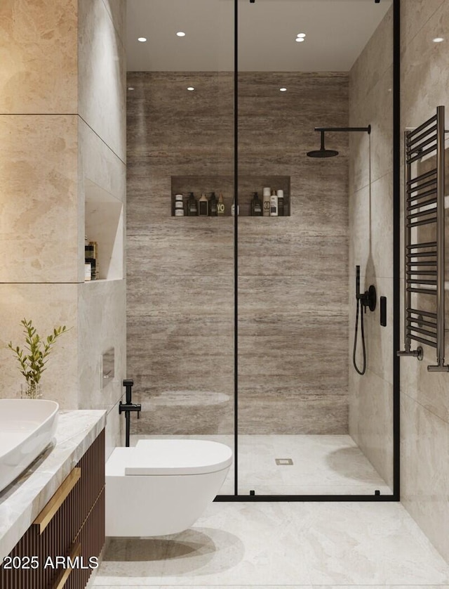 bathroom with vanity, a tile shower, radiator heating unit, and tile walls