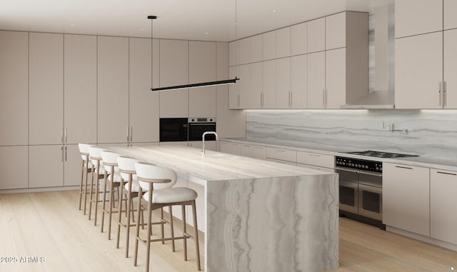 kitchen featuring stainless steel oven, wall chimney range hood, a large island, a breakfast bar area, and gas cooktop