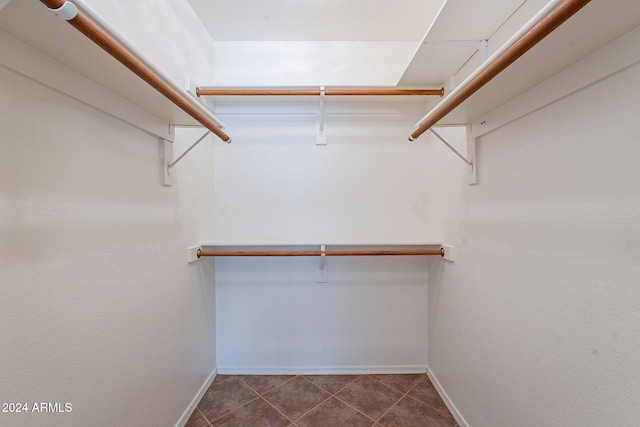 spacious closet with dark tile patterned floors