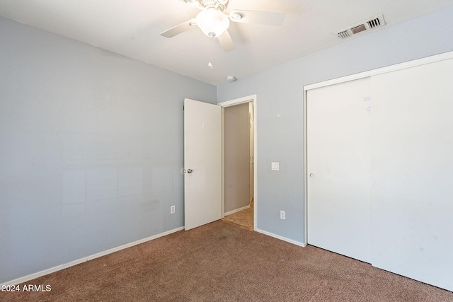 unfurnished bedroom featuring carpet, ceiling fan, and a closet