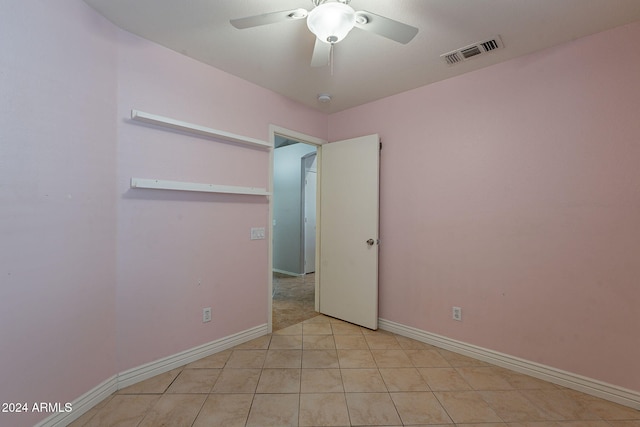 tiled empty room featuring ceiling fan