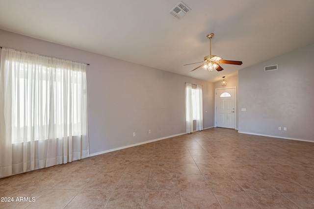 empty room featuring light tile patterned floors, vaulted ceiling, and ceiling fan