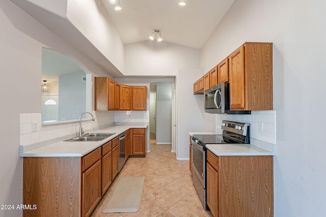 kitchen with decorative backsplash, stainless steel appliances, sink, light tile patterned floors, and lofted ceiling