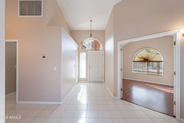 entrance foyer with high vaulted ceiling and light tile patterned flooring