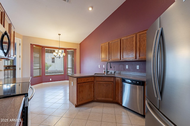 kitchen with sink, stainless steel appliances, decorative light fixtures, vaulted ceiling, and kitchen peninsula