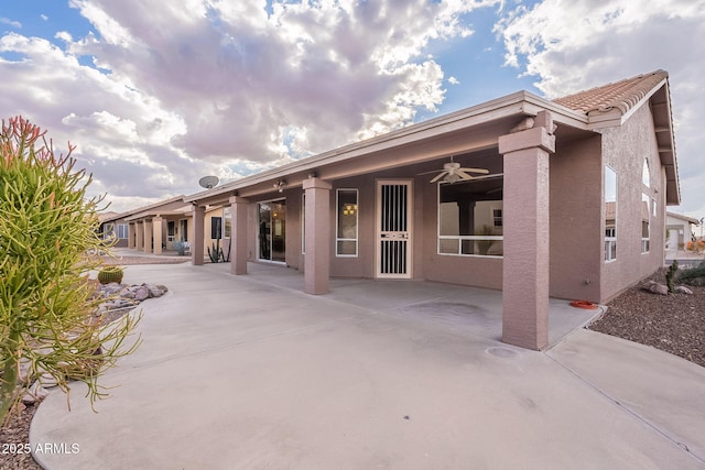 rear view of property featuring a patio and ceiling fan