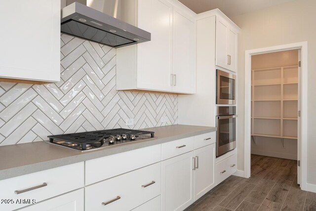 1571 E Tiffany Way, Gilbert, AZ 85298 - kitchen featuring wall chimney exhaust hood, appliances with stainless steel finishes, dark wood-type flooring, decorative backsplash, and white cabinets