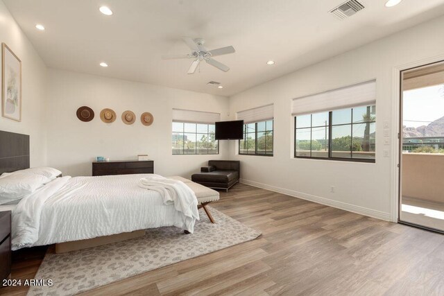 bedroom featuring connected bathroom and light hardwood / wood-style flooring