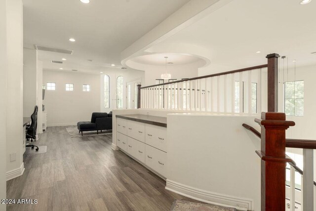 rec room featuring hardwood / wood-style floors, a tray ceiling, and a healthy amount of sunlight