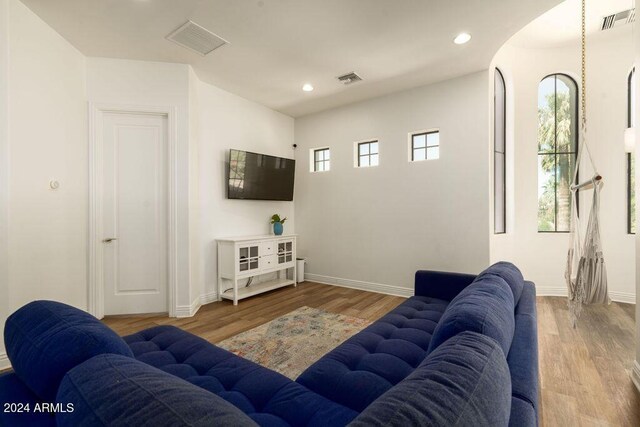 bedroom with ceiling fan, light hardwood / wood-style flooring, and multiple windows