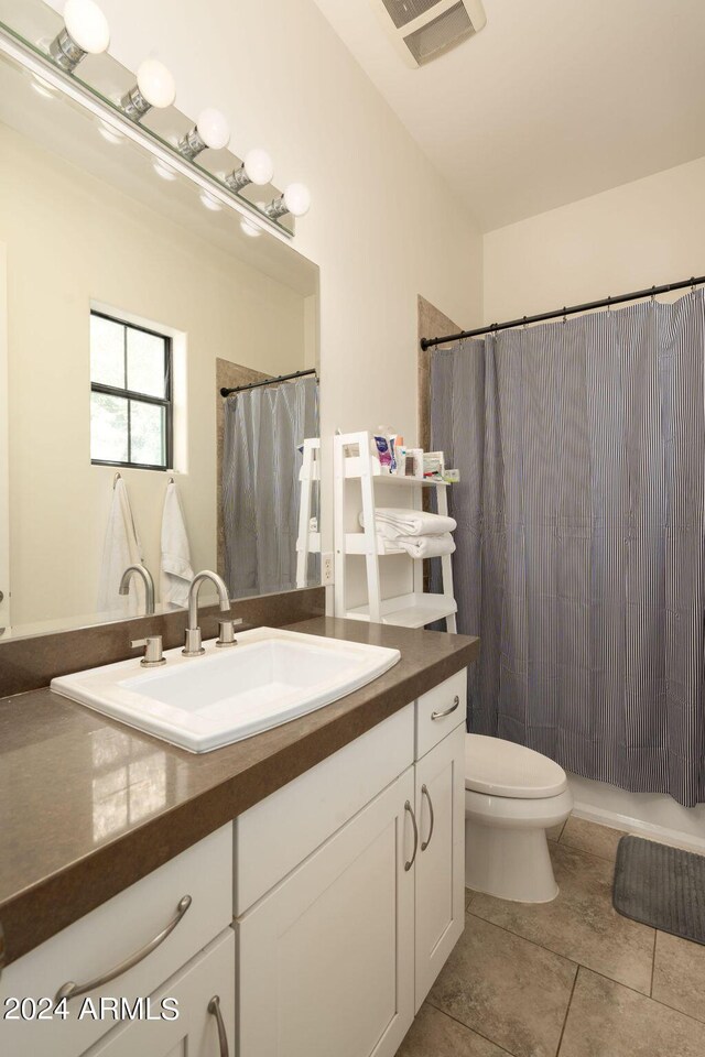 bathroom featuring tile patterned flooring, toilet, and vanity