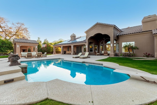 view of pool featuring a diving board, exterior fireplace, and a patio area